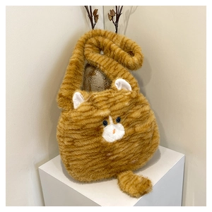 Close-up of fluffy orange tabby cat plush shoulder bag showing soft fur and cute blue eyes