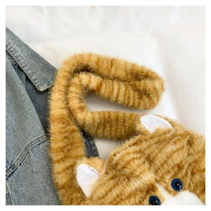 Macro shot of fluffy orange tabby cat plush bag showing soft texture and blue eyes