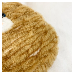 Macro shot of fluffy orange tabby cat plush bag showing soft texture and blue bionic eyes