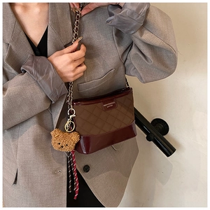 Détail du sac bandoulière matelassé avec chaîne et charmant pendentif en forme d'ours
