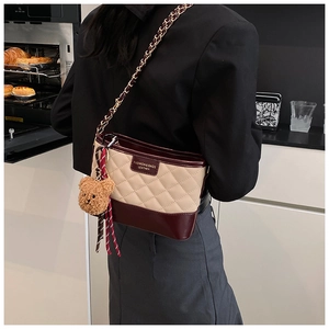 Détail des surpiqûres du sac hobo chic beige et bordeaux avec bandoulière chaîne