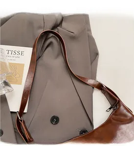 Detail of sturdy brown leather handle with reinforced stitching and black metal hardware