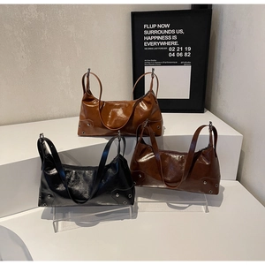 Three vintage hobo bags in caramel, coffee, and black with shiny leather and rivets