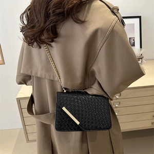 Chic black woven texture shoulder bag with gold chain strap and metallic detail