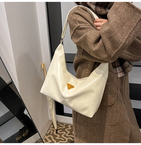 Detail of cream hobo shoulder bag with orange triangle logo on premium soft leather