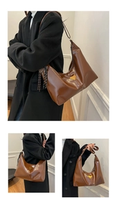Detail of a large brown hobo bag featuring a metal triangle plaque and woven tassel zipper