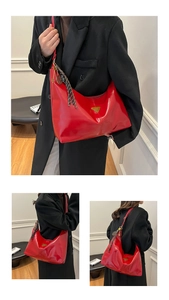 Detail of red glossy leather hobo bag with golden triangle logo and tassel keychain