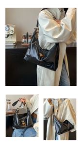 Detail of glossy black hobo bag with gold triangle logo and tennis racket charm