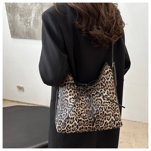 Dettaglio della borsa tote leopardata con fiocco nero indossata sulla spalla