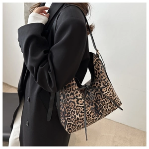 Dettaglio della borsa tote leopardata con coulisse in pelle nera e tracolla alla moda
