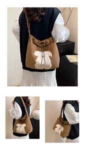Detail of brown corduroy hobo bag featuring a cute white teddy bear plush patch and drawstring