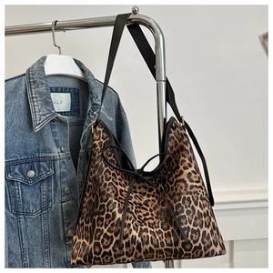 Vista dettagliata della borsa tote leopardata con coulisse a fiocco e manici neri
