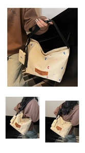 Detail of canvas bucket bag showing colorful letter embroidery and brown leather logo patch