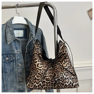 Dettaglio borsa hobo leopardata con tracolla in pelle nera e fiocco sul davanti