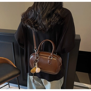 Sac bowling en cuir verni marron foncé avec breloques sport pour femmes stylées