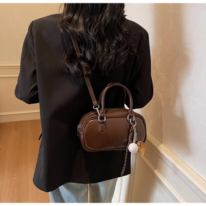 Sac Boston vintage marron avec breloque de baseball présenté en situation réelle