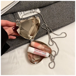 Detail view of heart-shaped gold clutch showing inner capacity for two lipsticks