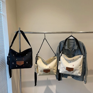 Three large canvas bucket bags in black, beige and white with colorful T-embroidery
