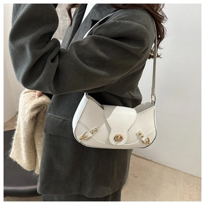 Detail of white hobo bag with gold twist lock and rivets on grey corduroy suit