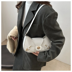 Detail of white matte leather underarm bag with elegant gold twist-lock and rivet accents