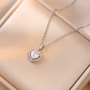 Primer plano de un collar con colgante de corazón brillante en una caja de regalo de seda