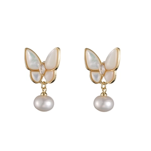 Détail de boucles d'oreilles papillon en perle avec monture dorée et nacre brillante