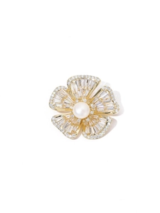 Detailed close-up of a floral brooch with a center white pearl and micro-pave zircons