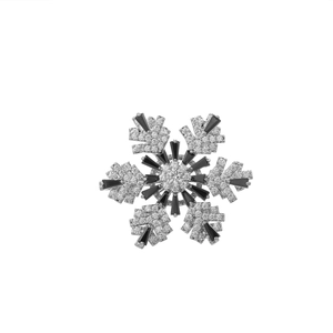 Dettaglio macro di spilla a fiocco di neve in argento con pietre nere e zirconi micro-pavé