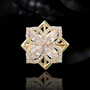 Eleganter goldener Blumenanstecker mit Marquise-Steinen und Kristallen auf schwarzem Grund