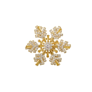 Dettaglio di una spilla a fiocco di neve dorata con cristalli scintillanti e zirconi