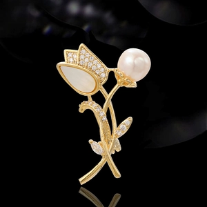Elegant gold tulip brooch featuring white shell petals, sparkling zircon, and a pearl
