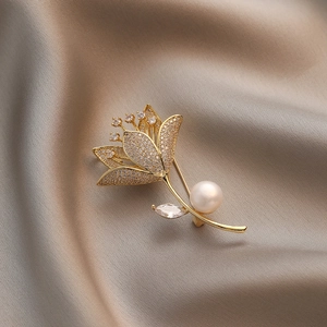 Elegante Magnolien-Brosche mit Kristallen und Süßwasserperle auf champagnerfarbener Seide