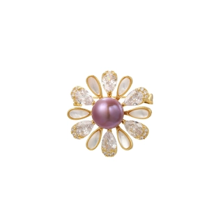 Détail d'une broche fleur avec perle violette, pétales en nacre et zircons brillants