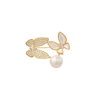 Macro detail of butterfly brooch with white zircon, mother of pearl and round pearl
