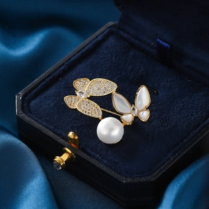 Elegant gold butterfly brooch with zircon wings and large white pearl in a velvet box