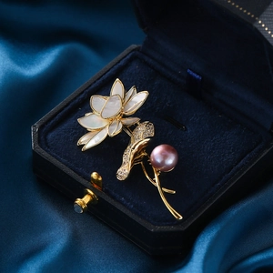 Eleganter Lotuseffekt-Brosche mit lila Perle und Perlmutt in einer Schmuckschatulle