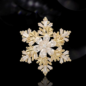 Élégante broche flocon de neige dorée avec cristaux de zircone sur fond sombre luxueux