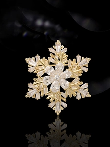 Détail macro de broche flocon de neige dorée ornée de cristaux de zircone brillants
