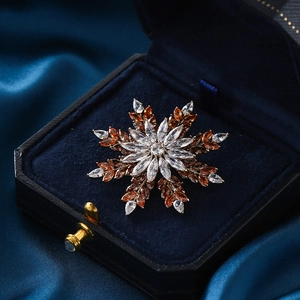 Exquisite snowflake brooch with amber and white marquise-cut zircons on blue velvet