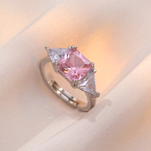 Eleganter verstellbarer Ring mit rosa Zirkon und seitlichen Dreieckssteinen auf Satin