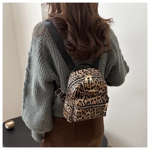 Mini leopard print backpack shown on a model wearing a grey knitted sweater