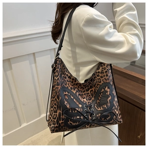 Detail of leopard print tote featuring butterfly leather patch and lace-up design