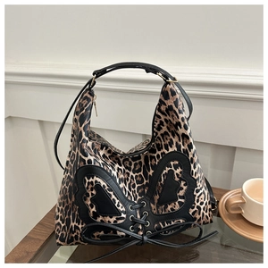 Leopard print crossbody bag detail with black heart patch and cross-lace design