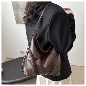 Detail view of large dark brown PU leather shoulder bag with diagonal zipper accents