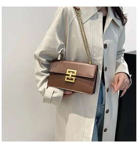 Braune Umhängetasche aus Leder mit goldener Kette und Verschluss am Model