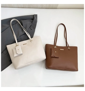 Detail of two-piece tote bag set in brown and off-white with pebbled faux leather texture