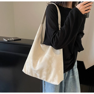 Dettaglio della grande borsa hobo bianco crema con texture morbida sulla modella
