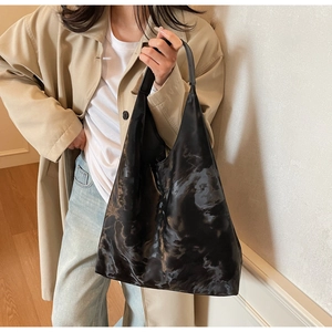 Dettaglio della borsa tote nera tie-dye marmorizzata con consistenza morbida e capiente