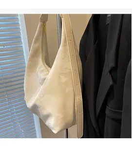 Detail of white cloud-textured tote bag showing the gold zipper and adjustable strap