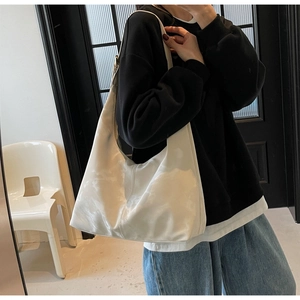 Detail shot of oversized cream hobo tote bag showing soft drape and nylon texture
